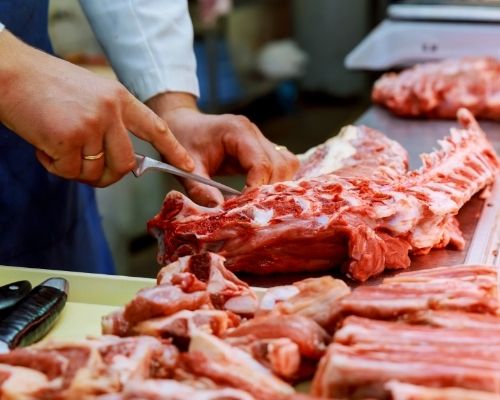 Image of Butcher cutting meat 