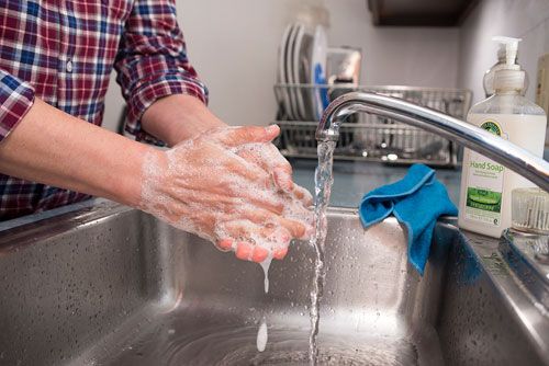 Man washes household dust off his hands. 